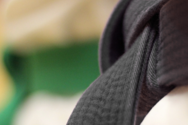 Detailaufnahme des schwarzen Guertels eines Judoka.